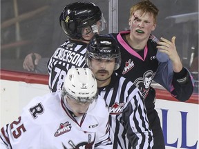 Crystal Schick/ Calgary Herald CALGARY, AB -- Calgary Hitmen Michael Zipp gestures to his bloody forehead after a fight with Red Deer Rebels' Adam Musil, who skates away with bloody knuckles, during game action at the Saddledome in Calgary, on November 23, 2014. The Hitmen dominated 6-2. --  (Crystal Schick/Calgary Herald) (For Sports story by  Laurence Heinen) 00060632A