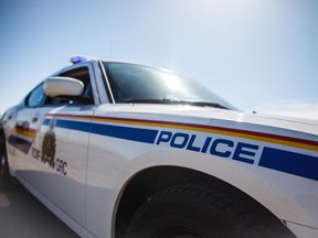 File photo of an RCMP logo and police cars outside of Calgary on Friday, April 10, 2015.