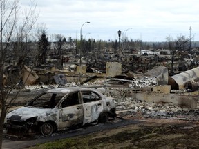 A burned out car and houses are shown in the Beacon Hill neighbourhood during a media tour of the fire-damaged city of Fort McMurray, Alta. on Monday, May 9, 2016. THE CANADIAN PRESS/Jonathan Hayward