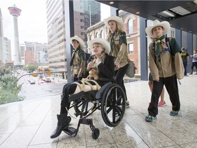 Kennedy Rhodes is pushed in her wheelchair by friend Selena Workun, flanked by Nolan Labinowicz (L), Brooke Burden (pink shoes) and Lyander Thrienen as they and the Mighty 70th Explorers walk through a Plus 15 in downtown Calgary, Alta., on Saturday, June 25, 2016. Rhodes lost her leg about six weeks ago in an accident with a train while playing in a rail yard, and her Explorers group wanted to get her out on an adventure to help lift her spirits.