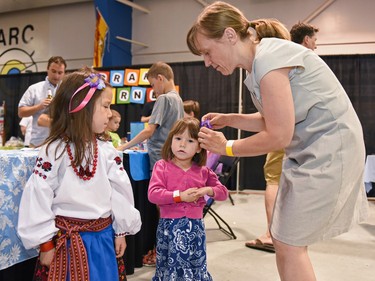 Cheryl Dannis puts a flower pin in her daughter Ava's hair at the Calgary Ukrainian Festival, in Calgary on Sunday, June 5, 2016.Elizabeth Cameron/Postmedia