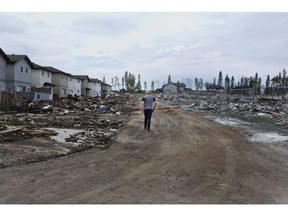 A Fort McMurray resident looks over the damage in the neighbourhood of Timberlea in Fort McMurray, Alta., on Wednesday June 1, 2016. Residents and business people returned after being evacuated during wildfires.