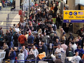 Massive lines fill the departure area as travellers wait to clear security at the Calgary International airport .