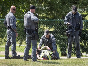 Police arrest a man at the corner of Douglasdale Blvd and Douglas Wood Rise S.E. in Calgary on Tuesday, June 28, 2016. A man driving a tow truck was arrested by heavily armed police.