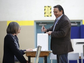 Assembly of First Nations National Chief Perry Bellegarde, right, casts his vote in the 2015 federal election at the Hopewell Avenue Public School polling station in Ottawa on October 19, 2015.