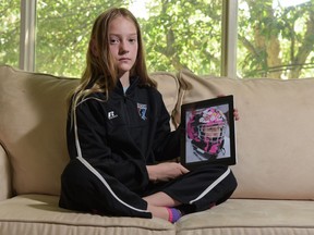 Jorja Fisher, 11, holds an image of her goalie helmet that was recently stolen in Calgary on June 26, 2016. Fisher, who began playing hockey when she was 5, was known on the ice for her pink helmet and goal-tending skills. Elizabeth Cameron/Postmedia