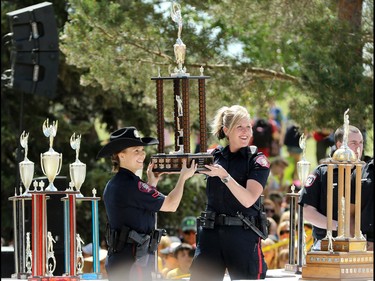 Calgary police officers hold up one of the top trophies during an awards ceremony for over 7000 Calgary AMA School Safety Patrollers during a fun-filled day appreciation day at Heritage Park on Thursday June 9, 2016. Patrollers have been keeping kids safe in crosswalks for 79 years since 1937.