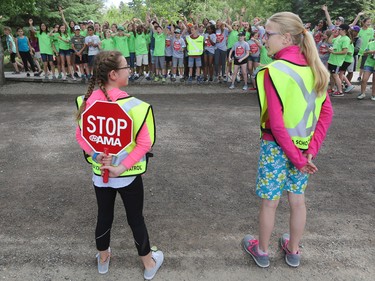 AMA School Safety Patrollers Katharine Ottenbreit, right and Olivia Sharpe from St. Philip school wait for the onslaught of fellow patrollers as they conduct a demonstration crossing during a fun-filled day appreciation day at Heritage Park on Thursday June 9, 2016. Patrollers have been keeping kids safe in crosswalks for 79 years since 1937.