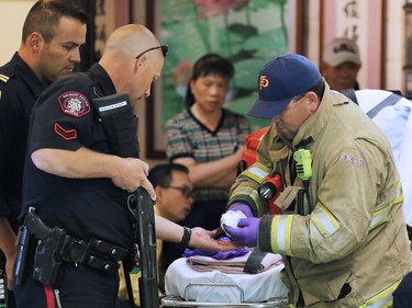 A Police officer has his blood covered hands washed at a stabbing incident in the Perpetual Wellness Chinese Medicine Centre on Thursday June 16, 2016