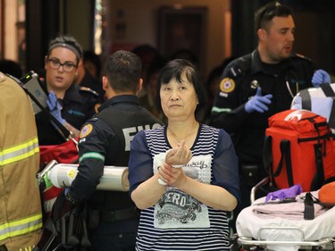 A woman with an apparent stab wound is escorted by EMS from a stabbing incident in the Perpetual Wellness Chinese Medicine Centre on Thursday June 16, 2016