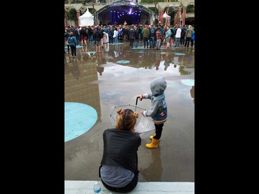 Fans enjoy a gap in the showers listening to Built to Spill in Calgary's Olympic Plaza during the Sled Island Music Festival on Saturday June 25, 2016.