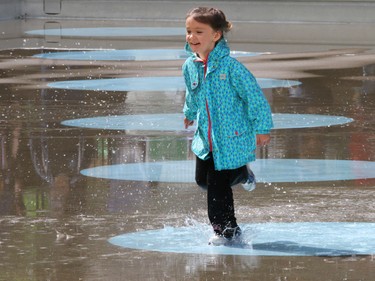 Anna Herron, 4, enjoys a splash through Calgary's Olympic Plaza during a break between performances and thunderstorms at the Sled Island Music Festival on Saturday June 25, 2016.
