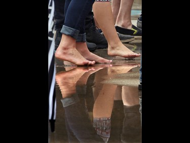 Some audience members ditched the shoes to do some foot tapping to the music in the puddles at Calgary's Olympic Plaza during the Sled Island Music Festival on Saturday June 25, 2016.