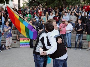 Two people embrace as an estimated 500 Calgarians gathered at Olympic Plaza on Sunday in a show of solidarity for the victims of the mass shooting in Orlando, Fla., and for the LGBTQ community.