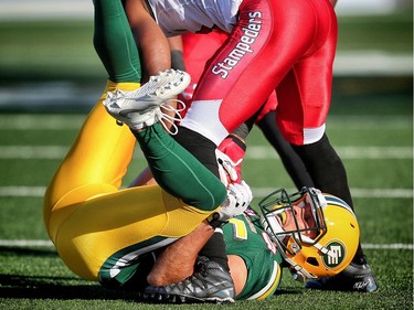 Edmonton Eskimos receiver Nate Coehoorn takes a hit from Josh Bell of the Calgary Stampeders in CFL pre-season action at Calgary's McMahon Stadium on June 11, 2016.