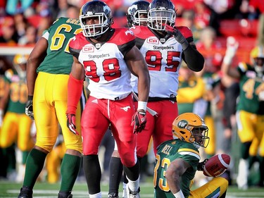 Calgary Stampeders Brandon Boudreaux and Uriah Grant after knocking down Shakir Bell of the Edmonton Eskimos in CFL pre-season action at Calgary's McMahon Stadium on June 11, 2016.