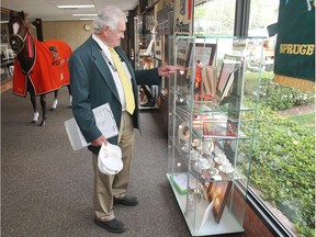 Bas French, a day one volunteer at Spruce Meadows, looks over the display case and tribute to Ron Southern Wednesday June 8, 2016 on the opening day of The National.