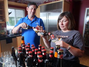 Mike Tessier and partner Bo Vitanov pour themselves beer from Trou du Diable of Shawinigan, Quebec in their St Andrews Heights home Monday June 27, 2016. The couple run Artisan Ales, a beer importing company they say has been hit hard by changes in taxes imposed by the provincial government.