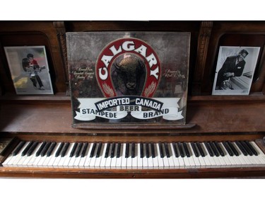 Signed photos of Chuck Berry and Fats Domino frame a Calgary Brewery mirror circa the 1970's on top of a battered piano at Kelly Jay's home in Penbrooke Meadows.