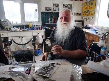 Kelly Jay holds a photo of himself while sorting through the chaos in his Penbrooke Meadows home.