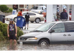 Dave Beddows waits for a tow for his swamped van at the flooded intersection of Braeside Drive and Southland Drive after  the heavy downpour Tuesday afternoon June 28, 2016. (Ted Rhodes/Postmedia)