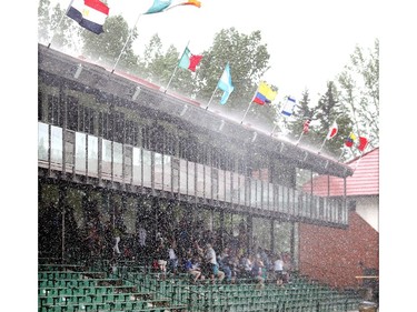 Fans in the lower seats scramble for cover as a squal rips through the ring during the Erwin Hymer Group Cup at Spruce Meadows Wednesday June 8, 2016 on the opening day of The National.