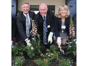 Jay Westman, left, of Jayman Built and Alan Norris of Brookfield Residential, are joined by Cindy Ady of Tourism Calgary in a ceremonial flower bed planting following the ceremonies marking the opening of the two new Marriott Hotels, The Courtyard and the Residence Inn, in Seton.