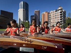 The Harmony Guzheng Orchestra performs next to the Bow River pathway across from the Harry Hays Building in downtown Calgary, on Wednesday, June 29, 2016. The city was beginning to set up for its big multi-venue Canada Day party downtown.