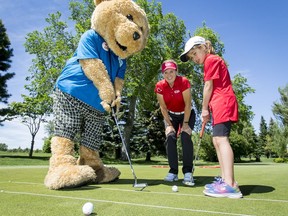 Canadian golf icon Lorie Kane and Alberta Children's Hospital (ACH) mascot Dr. Teddi help Alexa Castillo, 8, an ACH ambassador and cardiac patient, with a putt during the Kids Helping Kids Junior Golf Classic at Silver Springs Golf and Country Club in Calgary, Alta., on Sunday, June 12, 2016. Kids IN the tourney raised more than $15,000 for cardiac care and research at the Alberta Children's Hospital; it was matched by Canadian Pacific, putting the total over $30,000. Lyle Aspinall/Postmedia Network