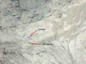 A photo posted by the Kananaskis Country Public Safety Section of  a man's blue and white canopy visible on a large rock face.
