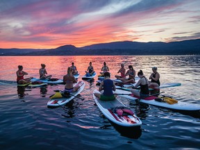 Laura Martini leads a stand-up paddleboarding yoga session on Okanagan Lake.