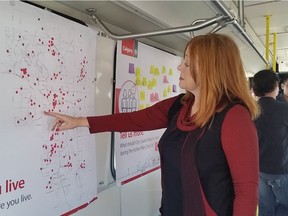 Coun. Diane Colley-Urquhart points out a location on a map of Calgary, where citizens have placed red stickers to show where they live. The map was inside the city's mobile town hall bus, parked in southwest Calgary on June 11, 2016 as part of an effort to get feedback from the public on budget priorities.