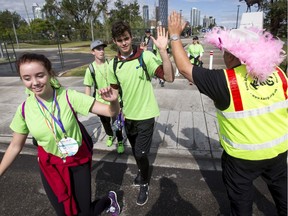 Darren Sumner of Boobs on Bikes encourages walkers participating in the One Walk to Conquer Cancer in Calgary, Alta., on Saturday, June 25, 2016. Hundreds of walkers took part in the event as the event raised almost $1 million for the Alberta Cancer Foundation.