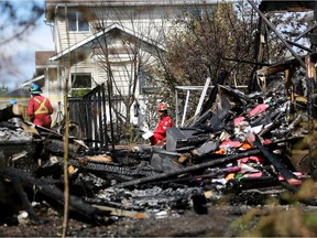 Fire investigators at the scene of a massive fire that destroyed two homes in Airdrie, Alta., on Saturday June 18, 2016.