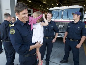 Capt. Hank Huculak carries his daughter Evera, 3, after he and the final group of Calgary firefighters returned from helping out with the Fort McMurray wildfires.