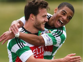 Foothills FC players Yoann Promonet, left, and Elijah Adekugbe celebrate a goal over the Washington Crossfire at Hellard Field in Calgary on Sunday, June 21, 2015.