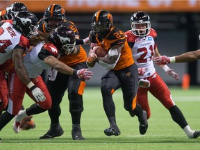 B.C. Lions' Jeremiah Johnson, second right, carries the ball past Calgary Stampeders' Frank Beltre, from left, Taylor Reed and Adam Berger, right, during the second half of a CFL football game in Vancouver, B.C., on Saturday June 25, 2016.