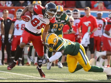 Calgary Stampeders DaVaris Daniels gets around a tackle by Edmonton Eskimos Kenny Ladler during CFL action at McMahon Stadium in Calgary, Alta.. on Saturday June 11, 2016. Mike Drew/Postmedia