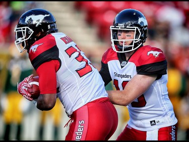 Calgary Stampeders quarterback, Bo Levi Mitchell, hands the ball off to running back Jerome Messam, during a game against the Edmonton Eskimos in CFL football in Calgary, Alta., on Saturday, June 11, 2016. Al Charest/Postmedia