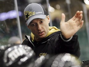 Dallas Stars head coach Glen Gulutzan speaks to players on the bench during NHL hockey training camp in Frisco, Texas, on Jan. 15, 2013.