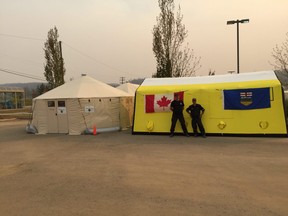 AHS fleet operations team leader Sam Primerano (R) stands with paramedic Greg Chop outside the ad hoc Fort McMurray urgent care centre, erected in the days after the city's devastating wildfire. Supplied photo