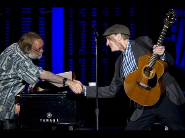 James Taylor shakes hands with his pianist Jim Cox between songs at the Scotiabank Saddledome in Calgary, Alta., on Wednesday, June 8, 2016. Lyle Aspinall/Postmedia Network