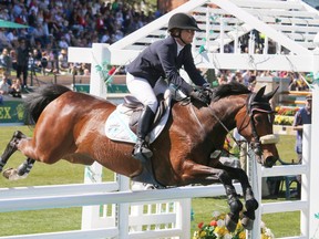Lisa Carlsen and World's Judgement on their way to a second place finish in the Nexen Cup at the Spruce Meadows National in Calgary, Ab., on Sunday June 12, 2016. Mike Drew/Postmedia