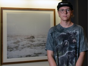 Philip Kanwischer is seen with his photographic artwork, currently on display at Arts Commons in Calgary.