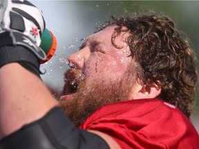 Stampeders big offensive lineman Spencer WIlson cools off during another hot day at CFL training camp practice in Calgary, Alta. on Monday June 8, 2015. Jim Wells/Postmedia