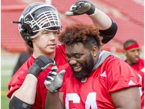 Dan Federkeil has a go at Derek Dennis's hair during the Calgary Stampeders training camp at McMahon Stadium in Calgary, Alta., on Thursday, June 2, 2016. The regular season begins on June 25, when the Stamps head to B.C.