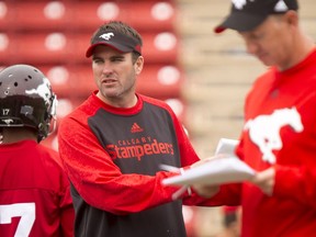 Quarterback coach Ryan Dinwiddie works as head coach Dave Dickenson walks by during the Calgary Stampeders training camp at McMahon Stadium in Calgary, Alta., on Wednesday, June 1, 2016. The regular season begins on June 25, when the Stamps head to B.C. Lyle Aspinall/Postmedia Network