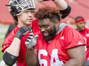 Dan Federkeil has a go at Derek Dennis's hair during the Calgary Stampeders training camp at McMahon Stadium in Calgary, Alta., on Thursday, June 2, 2016. The regular season begins on June 25, when the Stamps head to B.C. Lyle Aspinall/Postmedia Network