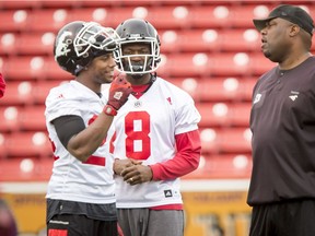 Joe Burnett (L) and Fred Bennett chat with defensive coordinator DeVone Claybrooks during the Calgary Stampeders training camp at McMahon Stadium in Calgary, Alta., on Thursday, June 2, 2016. The regular season begins on June 25, when the Stamps head to B.C. Lyle Aspinall/Postmedia Network