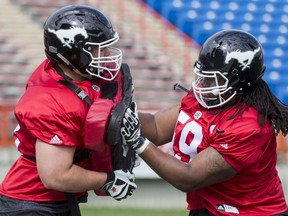 Roman Grozman (L) and Randy Richards run through a drill on Day 1 of the Calgary Stampeders rookie camp at McMahon Stadium in Calgary, Alta., on Thursday, May 26, 2016. Regular training camp was set to begin on May 29.  Lyle Aspinall/Postmedia Network